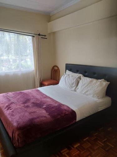 a bedroom with a large bed and a window at Townhouse Upper Hill Nairobi 2 in Nairobi