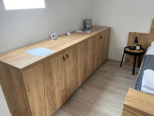 a wooden cabinet in a room with a bed at VATUS Apartmanház Vác in Vác