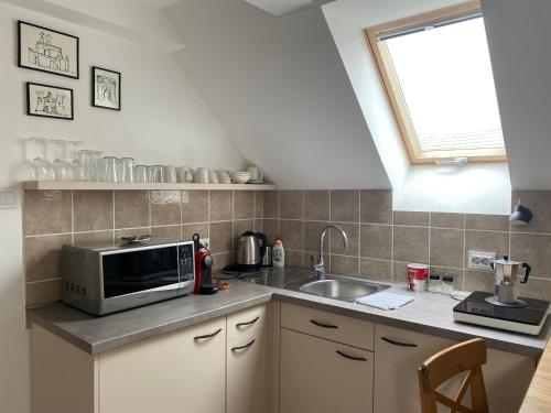a kitchen with a microwave and a sink at VATUS Apartmanház Vác in Vác