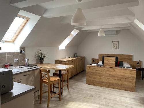 a kitchen with a table and chairs in a room at VATUS Apartmanház Vác in Vác