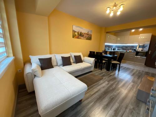 a living room with a white couch and a dining room at Nataly Homes in Veliko Tŭrnovo