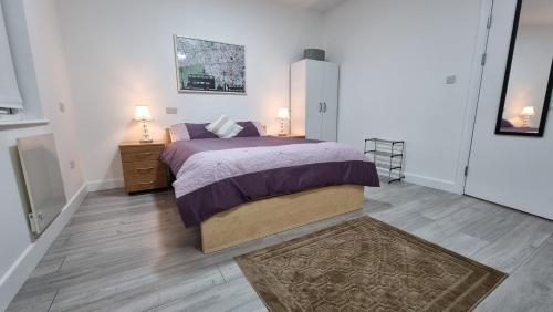 a bedroom with a large bed with two lamps on it at Brand New Flat Close To Turnpike Lane Tube Station in London