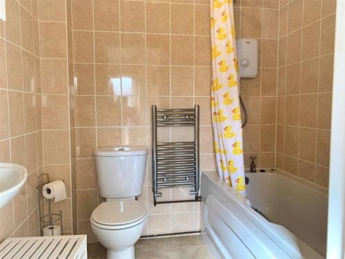 a bathroom with a toilet and a tub and a sink at 2 bed property in Gower 78344 in Reynoldston