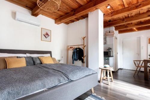 a bedroom with a large bed and wooden ceilings at Sarki-ház in Szigliget