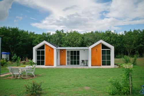 a house with orange doors and a yard at ไร่นภาดลรีสอร์ท in Mae Suai