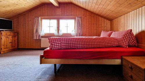Schlafzimmer mit einem Bett mit roter Bettwäsche und einem Fenster in der Unterkunft Gasthaus Rössli in Brülisau