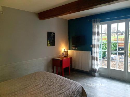 um quarto com uma cama, uma secretária e uma janela em Le Heron Pourpre B&B gastronomique em Cronat