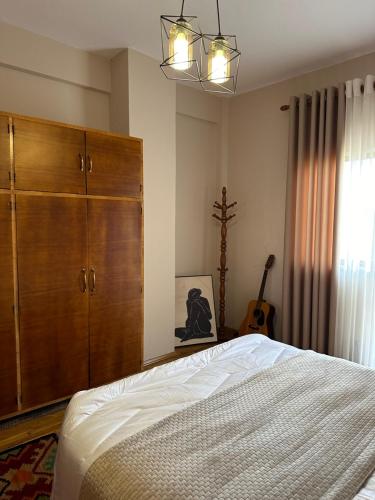 a bedroom with a bed and a large wooden cabinet at Villa Malo Guesthouse in Korçë