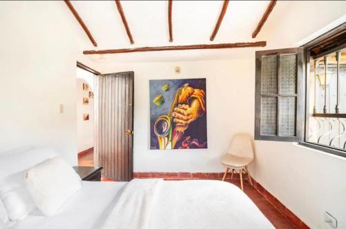 um quarto com uma cama e um quadro na parede em HERMOSA CASA CAMPESTRE 