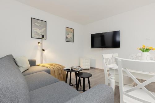 a living room with a gray couch and a table at Apartments City Center by Renters in Warsaw