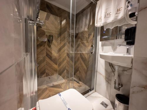 a bathroom with a shower and a toilet and a sink at AMASRA DADAYLI HOTEL in Amasra