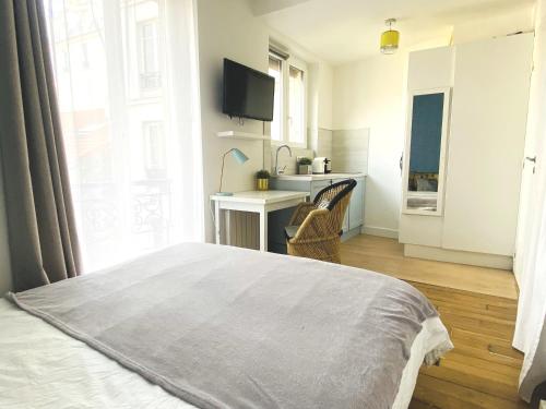 une chambre avec un lit et un bureau et une cuisine dans l'établissement Architect studio near Montmartre, à Paris