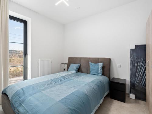 um quarto com uma cama com lençóis azuis e uma janela em The One 2 bedrooms on floor 0 em Blankenberge