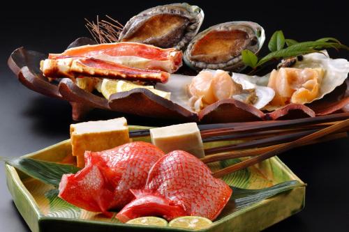 a plate of food with seafood and chopsticks at Yamayuri no Yado in Hanamaki