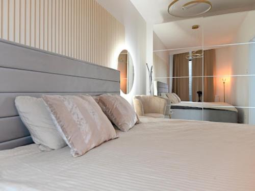 um quarto com uma cama branca e almofadas brancas em APARTAMENT TOPaZ 30 em Konin