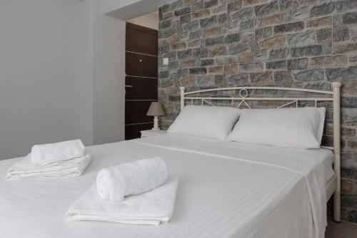 a bedroom with a white bed with towels on it at Petralona semi-basement apartment for 2 persons in Athens