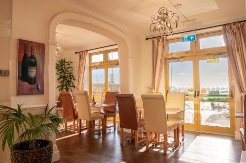 a dining room with a table and chairs and a window at Best Western Princes Marine Hotel in Brighton & Hove