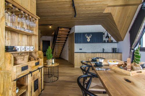 a kitchen and dining room with a table and chairs at Rozmus Apartamenty in Bukowina Tatrzańska