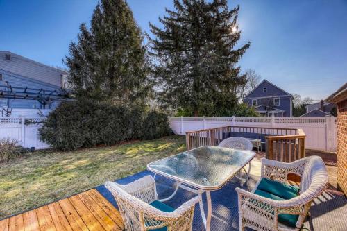 a patio with a table and chairs on a deck at Family Home near NY Beach - Private Workspace in Glen Head