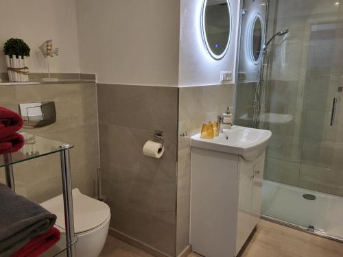 a bathroom with a toilet and a sink and a shower at Ferienwohnung Jasmin in Rust