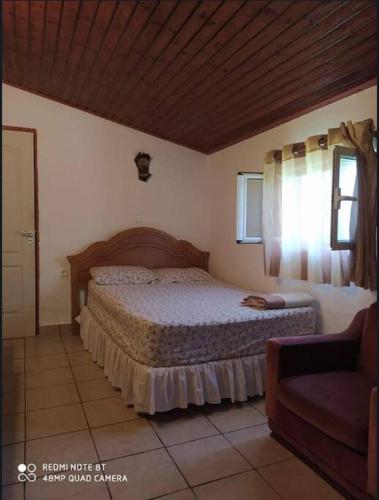 a bedroom with a bed and a window and a couch at Sarah Delight in Pýrgos