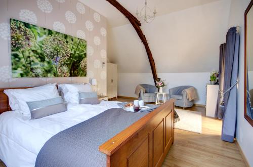 ein Schlafzimmer mit einem großen weißen Bett in einem Zimmer in der Unterkunft Les Charmes de Carlucet Gite-Beaux Reves in Saint-Crépin-et-Carlucet