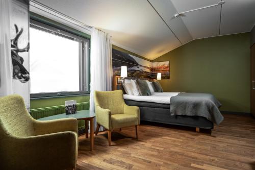 een slaapkamer met een bed en 2 stoelen en een raam bij Break Sokos Hotel Levi in Levi
