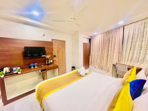una camera da letto con un grande letto bianco e una televisione di HOTEL EAGLE GRAND a Shamshabad