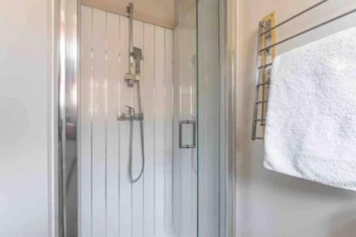 a shower with a glass door in a bathroom at Central Coventry Apartment in Coventry