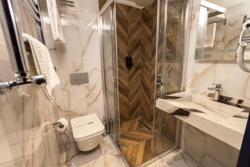 a bathroom with a shower and a toilet and a sink at AMASRA DADAYLI HOTEL in Amasra