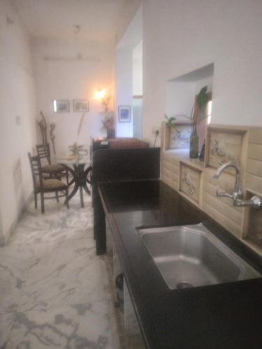 a kitchen with a sink and a living room at La Casa Art Stay in Udaipur