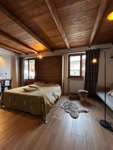 a bedroom with a bed in a room with wooden ceilings at Locanda Allevè Hotel Ristorante in Pragelato