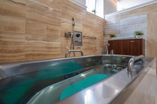 a bath tub in a bathroom with a sink at Hotel Radium Palace in Jáchymov