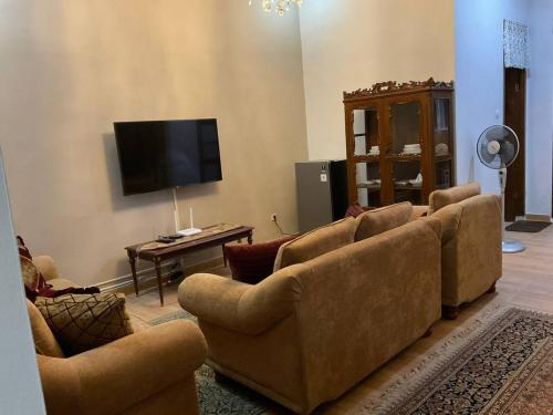 uma sala de estar com sofás e uma televisão de ecrã plano em Casa Setra Bandung em Bandung