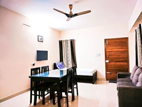 une salle à manger avec une table et un canapé dans l'établissement Primera Extended Stay Apartments, à Bangalore