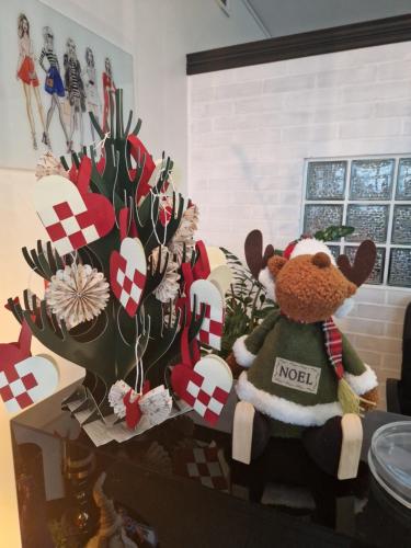 a teddy bear sitting on a table next to a christmas tree at Nowodworski in Nowy Dwór Gdański