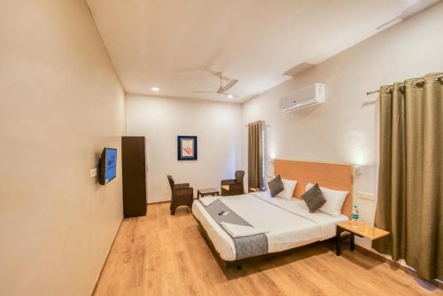 een slaapkamer met een bed en een tafel en stoelen bij Iyla Apart Hotel in Pondicherry
