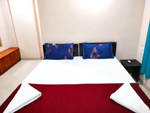 1 dormitorio con 1 cama con almohadas azules y rojas en Primera Extended Stay Apartments, en Bangalore