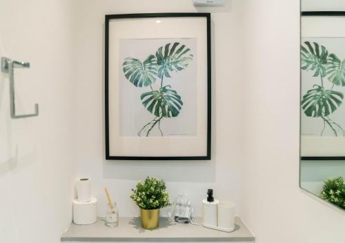 a bathroom with a framed picture of a palm tree at 4 Bedrooms Peaceful Home Abbey Rd - St Johns Wood in London