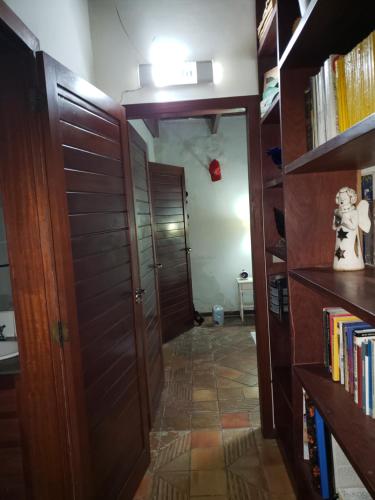 a room with a hallway with bookshelves and a door at 3QUARTOS PIPA4YOU in Pipa