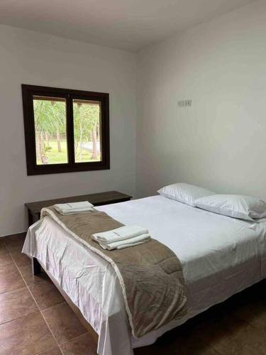 a bedroom with a bed with two towels on it at Rancho Jatobá in Bonito