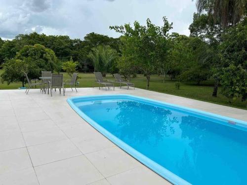 einen Pool im Garten mit Stühlen und Tischen in der Unterkunft Rancho Jatobá in Bonito