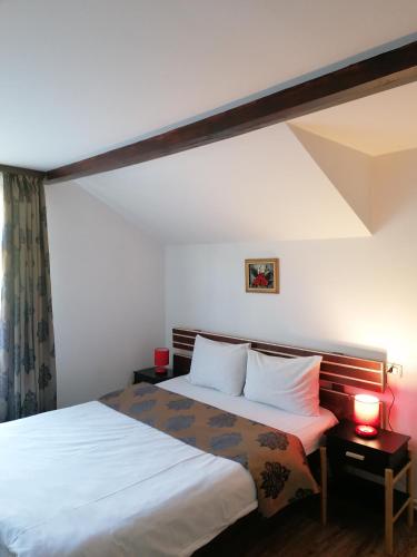 a bedroom with a large bed with white sheets at Cabana Gabriel Bucovina in Vatra Dornei