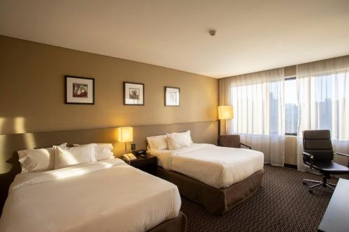 a hotel room with two beds and a window at Hilton Garden Inn Tucuman in San Miguel de Tucumán