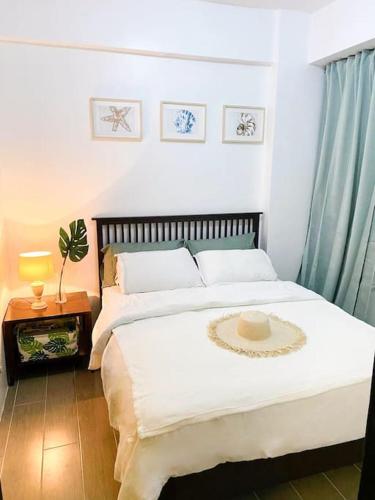 a bedroom with a large white bed with areath on it at Lushfield Boracay Guest House in Boracay