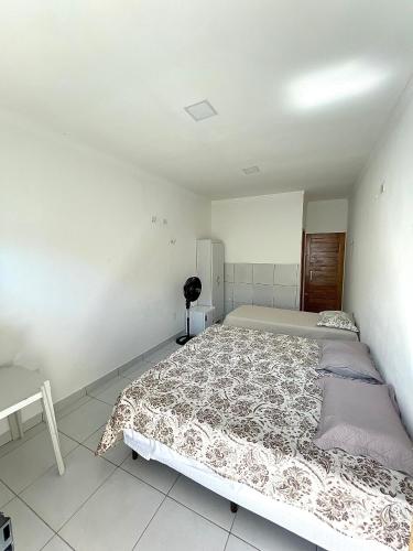 una camera da letto con un grande letto in una stanza bianca di Pousada Batista a Lagoa Nova