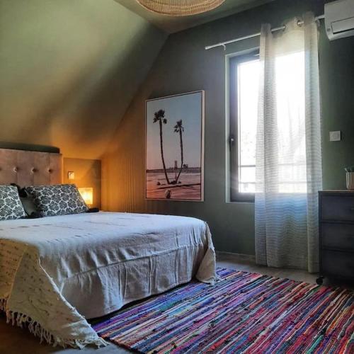 une chambre avec un lit et une fenêtre avec des palmiers dans l'établissement Le Vertigo proche centre histo avec 2 parkings, à Sarlat-la-Canéda