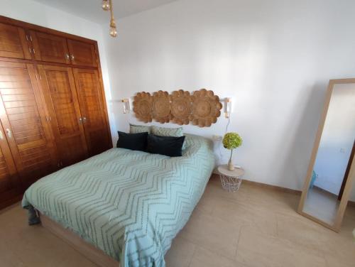 um quarto com uma cama com um edredão verde em VISTA ALMIJARA em Frigiliana