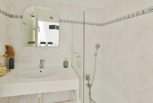 a white bathroom with a sink and a shower at L'Amandier Disneyland JO Paris 2024 pour 4 personnes et 1 bébé in Bailly-Romainvilliers