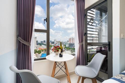 Cette chambre dispose d'une fenêtre avec une table et des chaises. dans l'établissement Goby home in Rivergate Luxury Apartment - near Ben Thanh market, à Hô-Chi-Minh-Ville